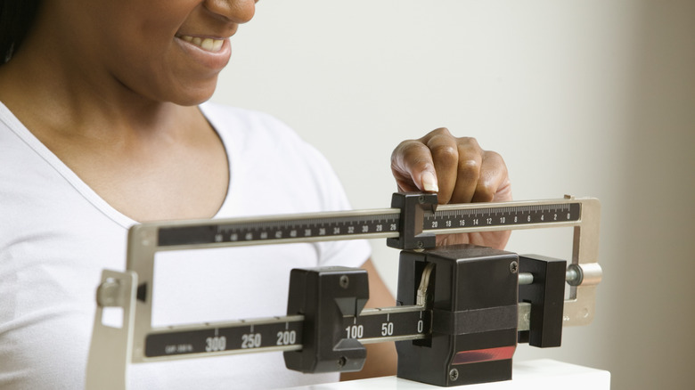 smiling woman adjusting scale