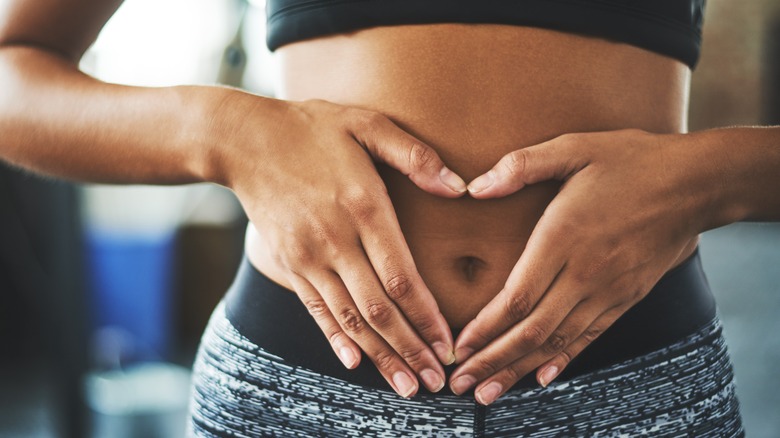 woman with hands making a heart against belly