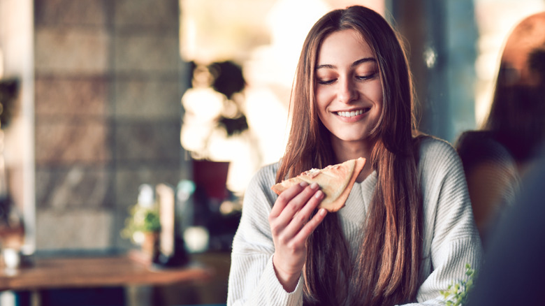 young woman eating a cheese sandwich