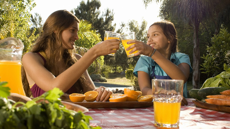 mother and daughter having orange juice