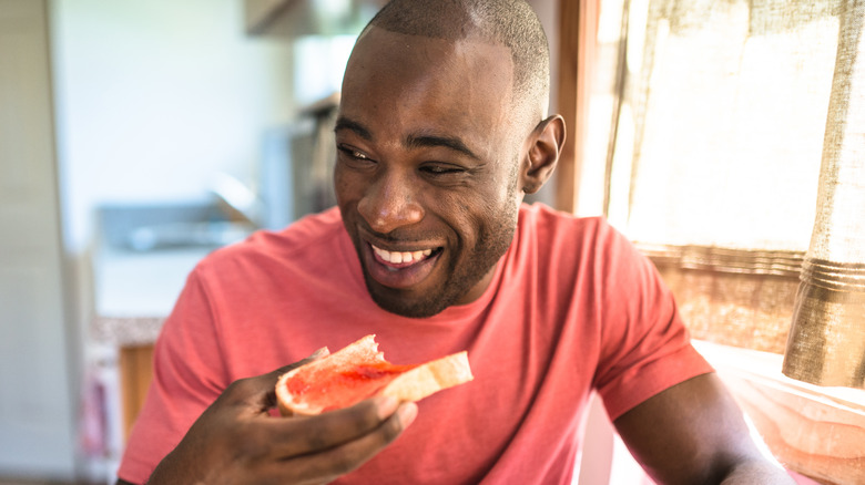 Smiling man holding toast