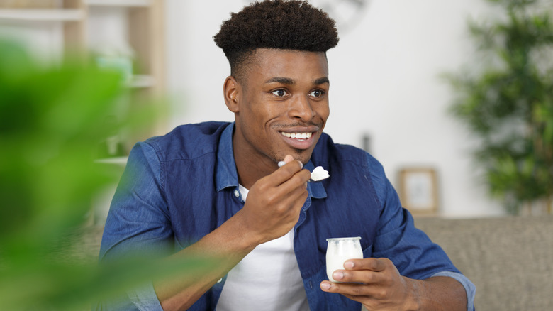 Smiling man eating yogurt
