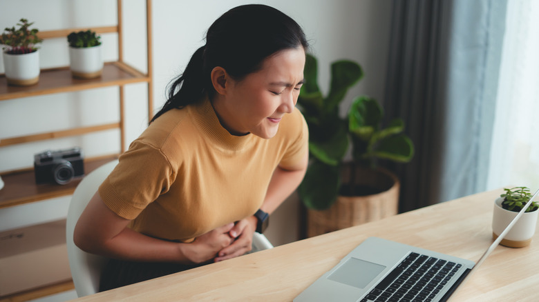 Woman holding stomach in pain