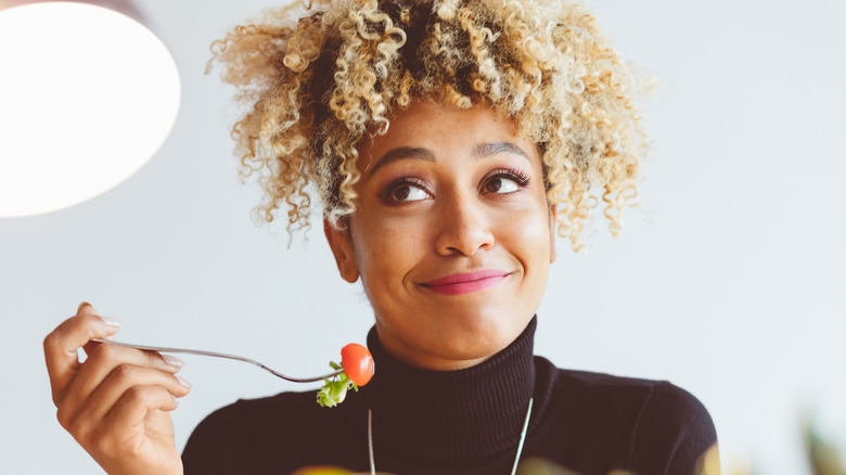 woman eating a grape tomato