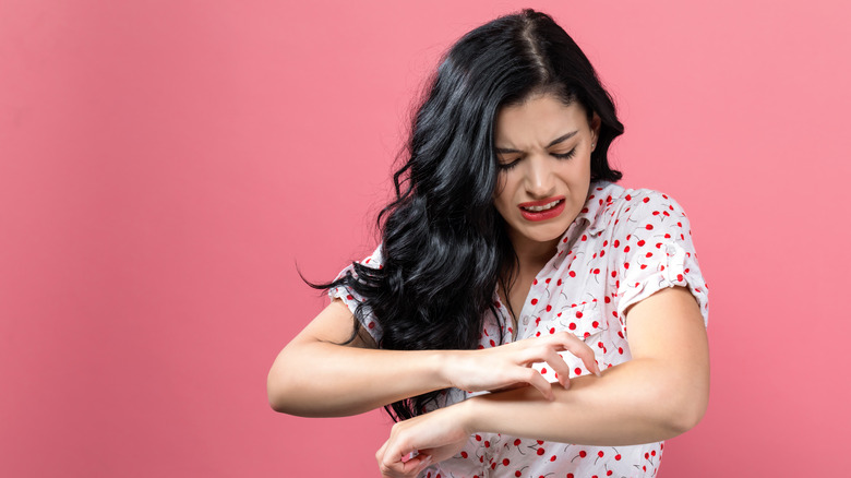 Woman itching her arm