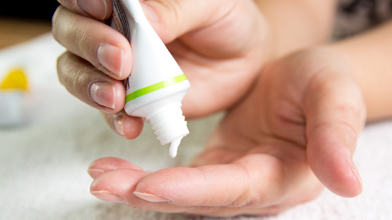 Person holding a tube of ointment