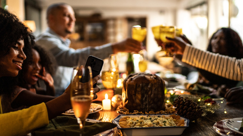 people cheersing at a holiday dinner spread