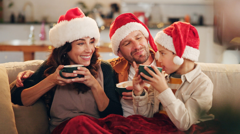 A family enjoying eggnog on the couch