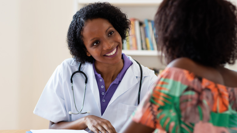 smiling doctor talking to patient