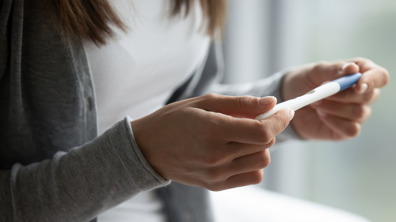 woman holding a pregnancy test