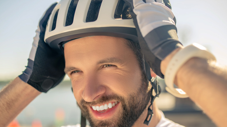 man putting on bike helmet