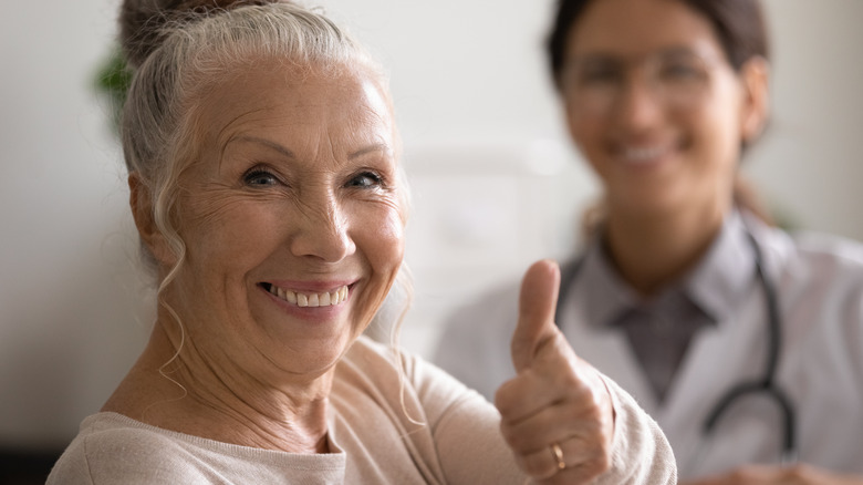 smiling elderly woman and doctor