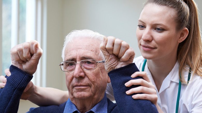 nurse helping stroke victim raise arms