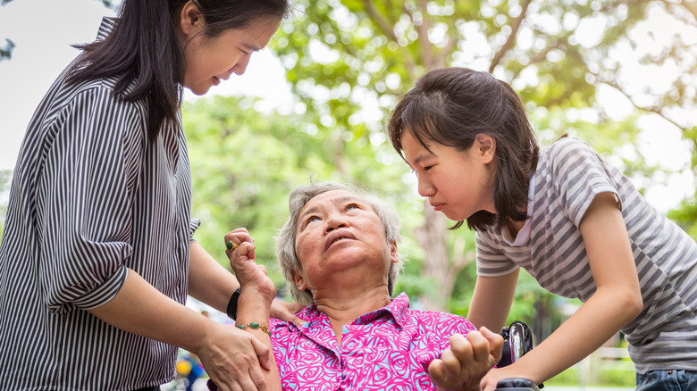 two granddaughters helping grandmother