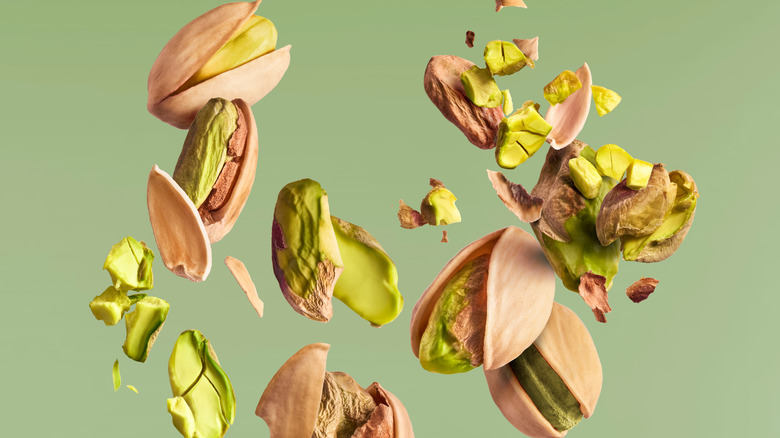 pistachios falling with green background