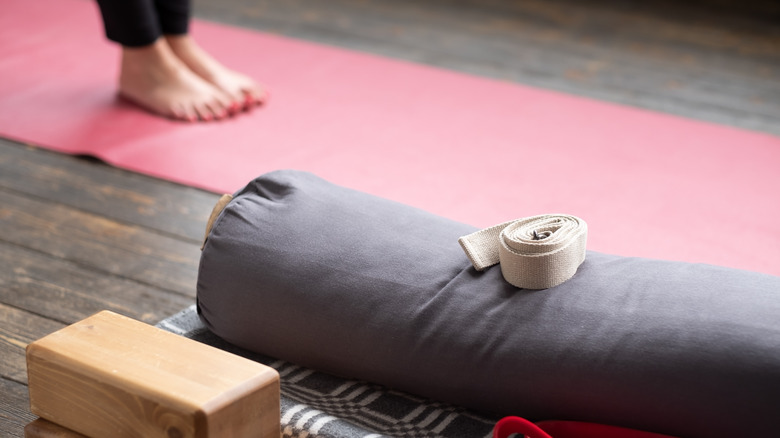 yoga props stacked with woman in background