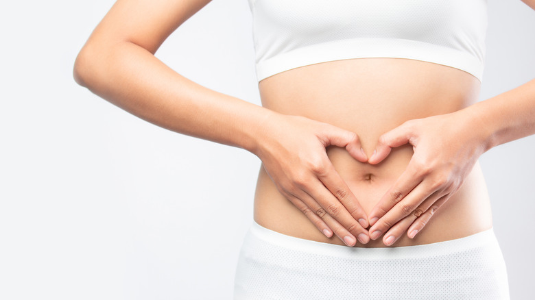 woman in athletic wear holding belly