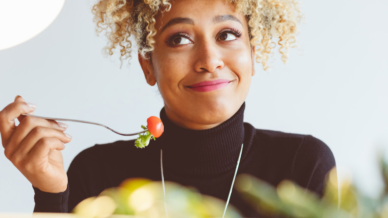 Woman eating a bowl of salad