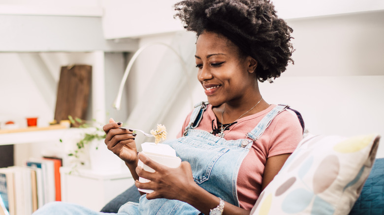 Woman eating pasta from bowl