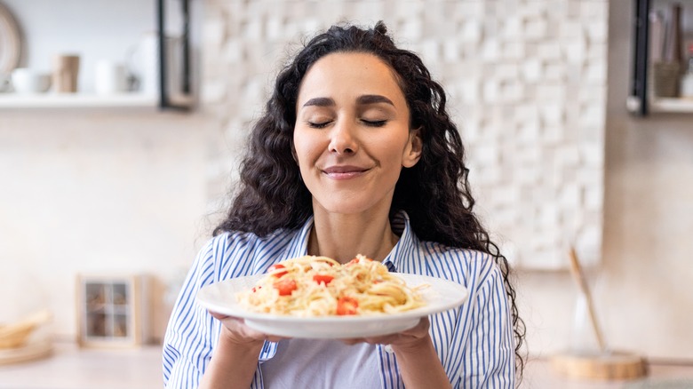 Happy woman enjoying her pasta