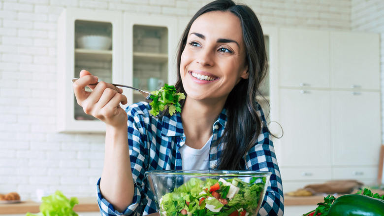 Woman happily eating a salad