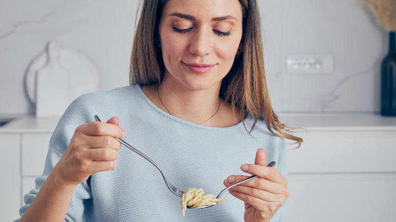 Woman holding pasta on her fork