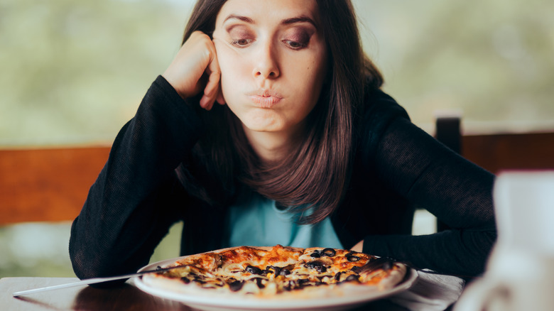 Woman looking upset at her food