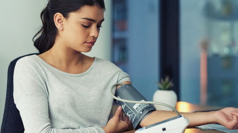 Young woman checking her blood pressure