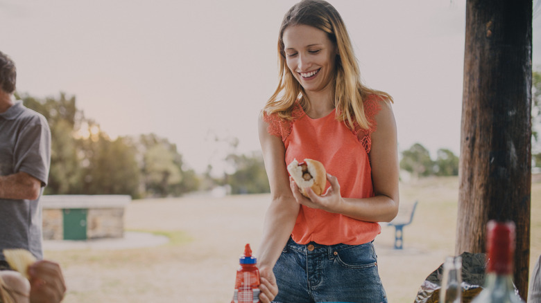 Woman using ketchup at a barbecue