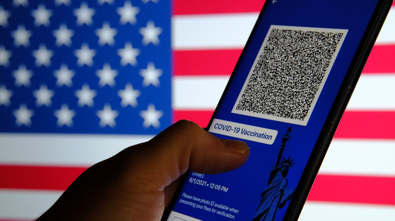 A smartphone app with a QR code indicating vaccine status on an American flag background