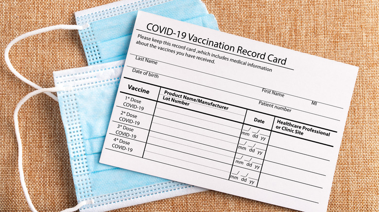 Vaccination card on top of two masks