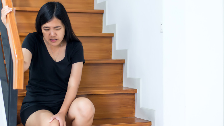 woman tired or in pain from walking stairs