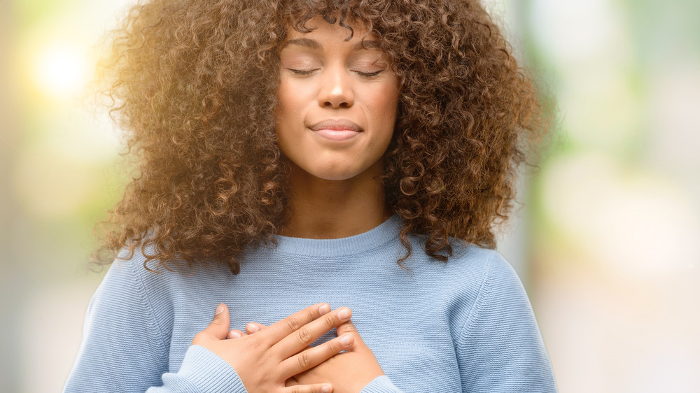 woman with hands over heart