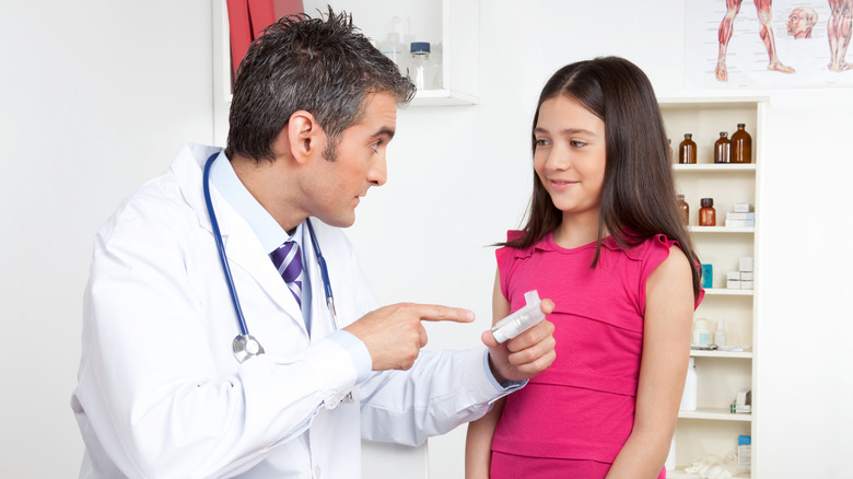 Doctor teaching child how to use an inhaler