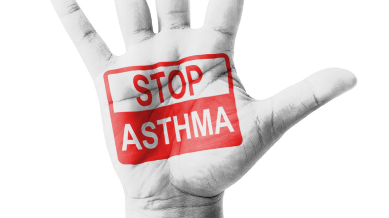 Hand with "stop asthma" sign