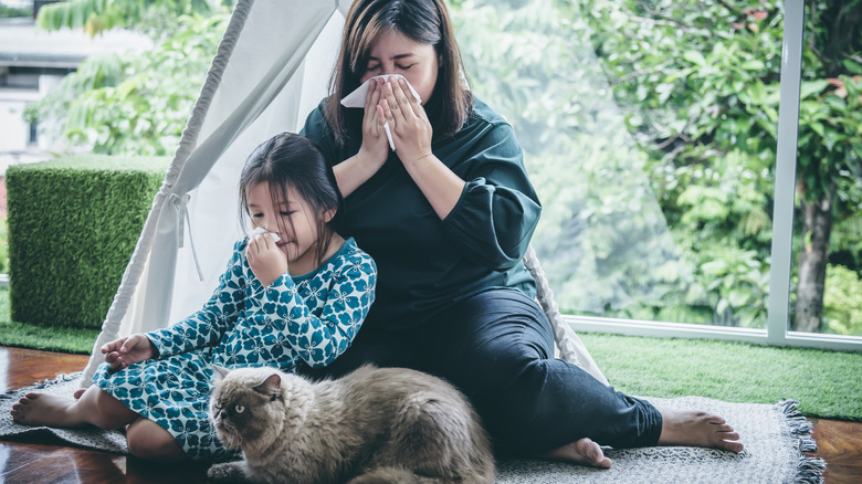 Mother and daughter blowing nose