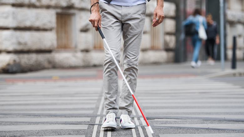 blind person walking in city street