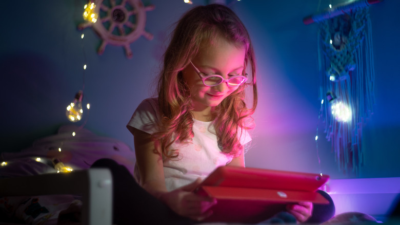 child with glasses looking at a screen