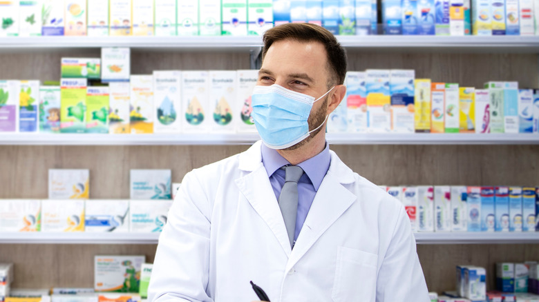 Doctor filling prescription at drugstore