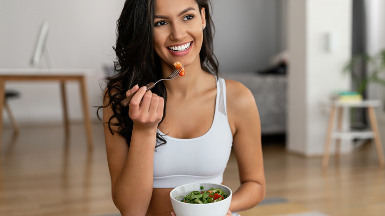 Woman eating salad after exercise
