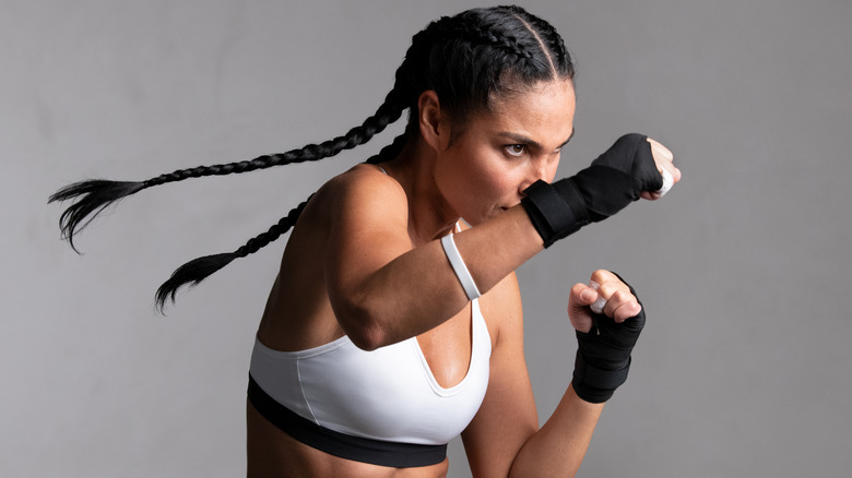 Woman practicing boxing with white background