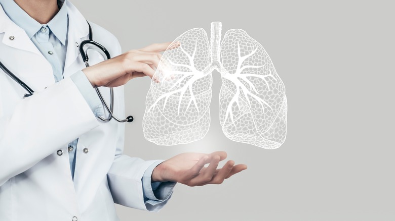 Doctor holding holographic lungs