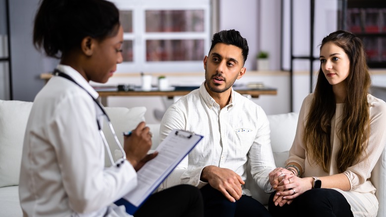 Couple consulting with doctor