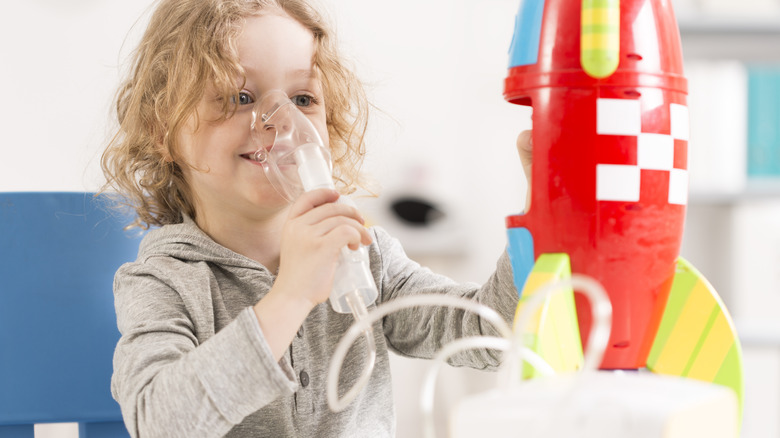 Child with mask playing with a rocket