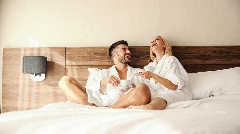 Couple in bed laughing together