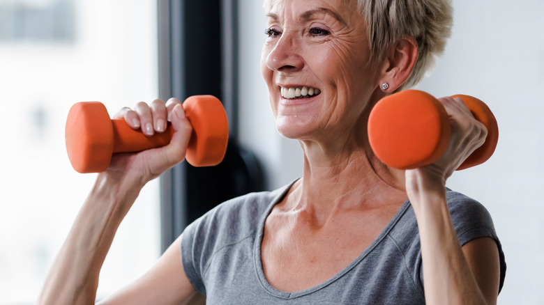 Woman doing dumbbell overhead press