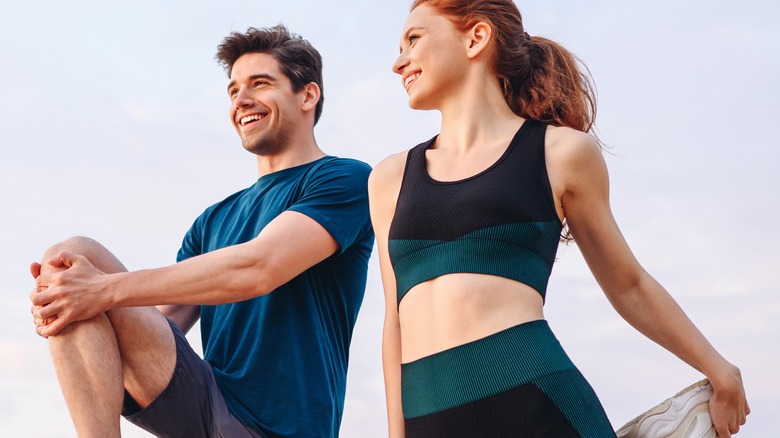 Two people stretching outdoors