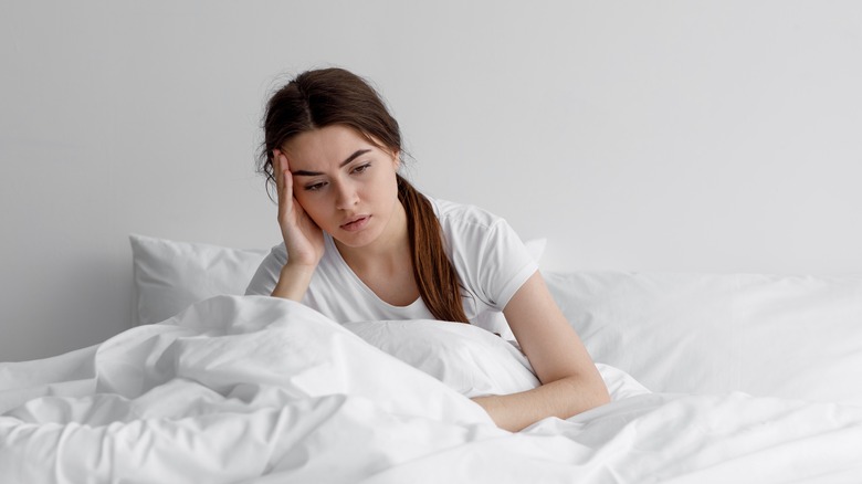 Woman in bed feeling sad