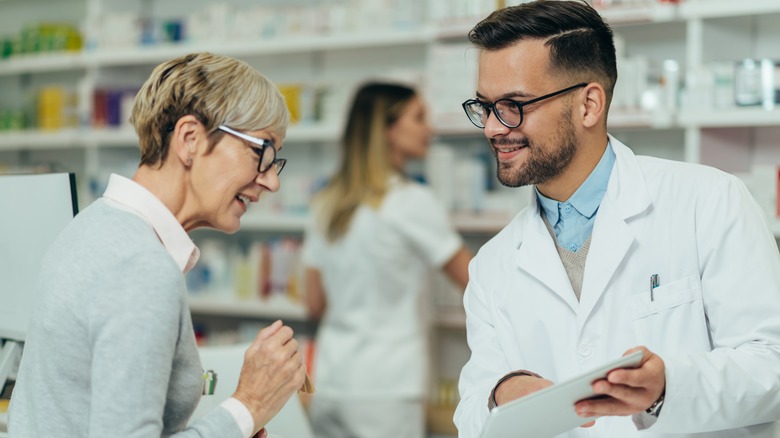 Pharmacist talking to senior woman