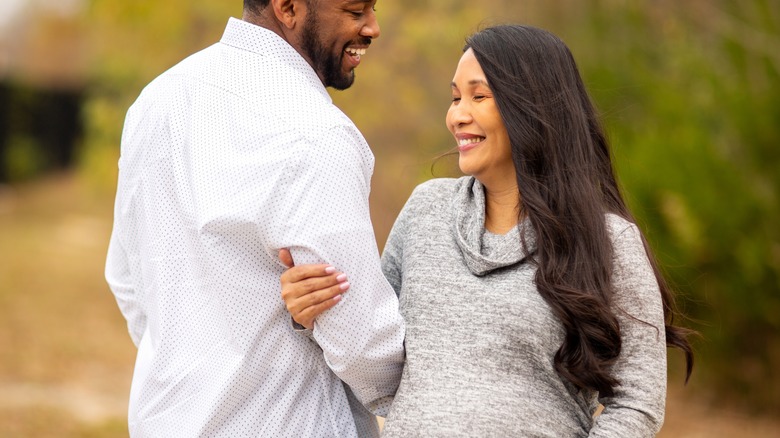 Happy pregnant couple in outdoor setting